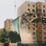 un excavator cu foarfecă taie cele 5 etaje distruse